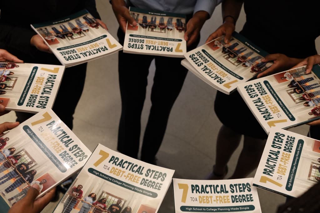 Copies of the book held in a circle, seen from above