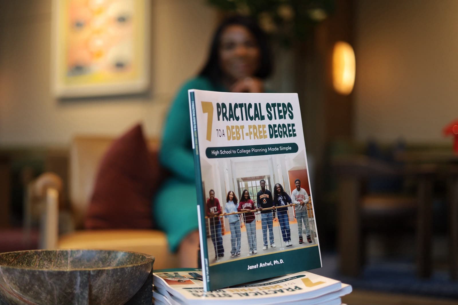 The book standing on a table, Dr. Janet Antwi seated behind it