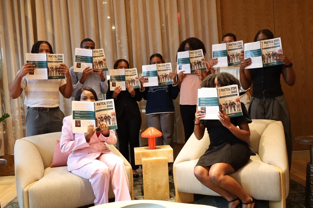 A group of students holding the book up in front of them
